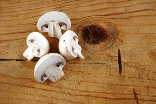 fresh champignon mushroom sliced on wooden background 