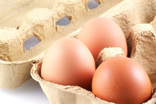 Three eggs in a box, isolated on white.            