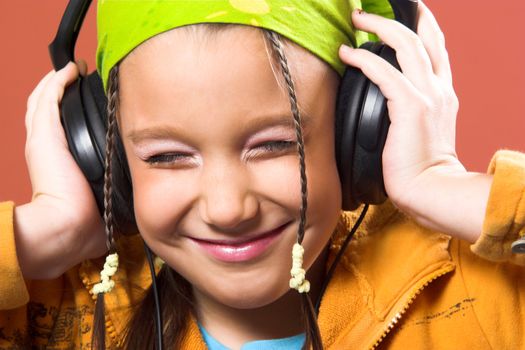 little pretty child listening music in headphones