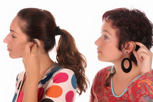 Two woman putting hearing aid into ear 