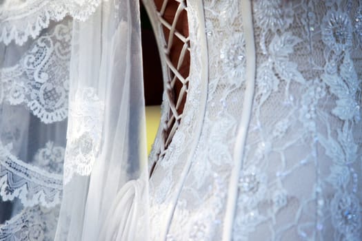 Detail of white wedding dress and veil