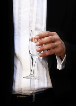 Glass of champagne in a hand of the groom