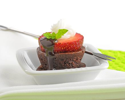 Delicious chocolate brownie topped with ripe strawberry.