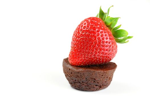 Fresh baked chocolate brownie and ripe strawberry.