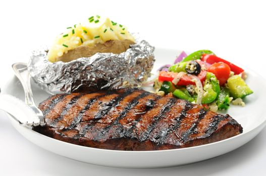 Grilled steak with baked potatoes and salad.