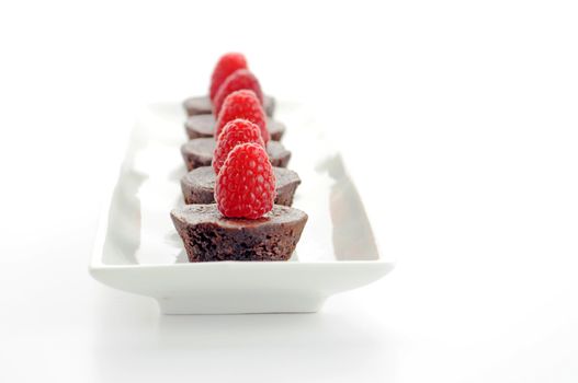 Tasty dessert of fresh chocolate brownies and raspberries.