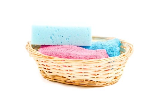 basket with colorfull towels and sponge isolated on white