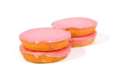 Pink glazed cookies stacked isolated on white
