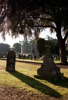 Early morning view of graveyard with distant church