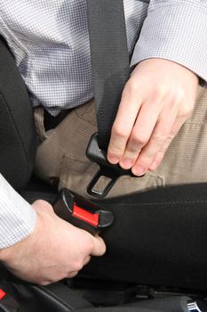 details of hands putting on safety belt