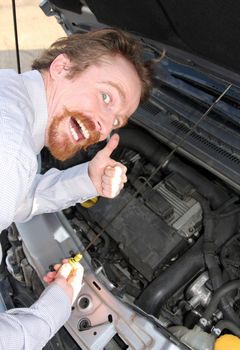 happy man checking engine oil dipstick in car