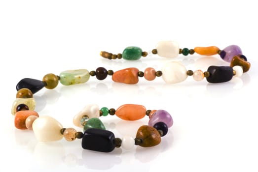 Necklace made of colorful natural stones isolated on white.