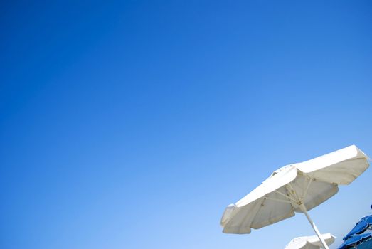 white and blue umbrellas on sunny beach