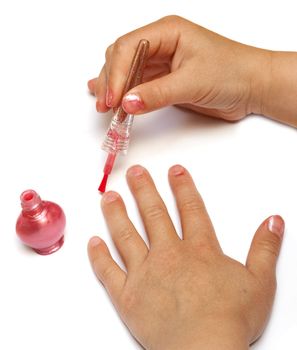 Child's hands putting on pink nail polish