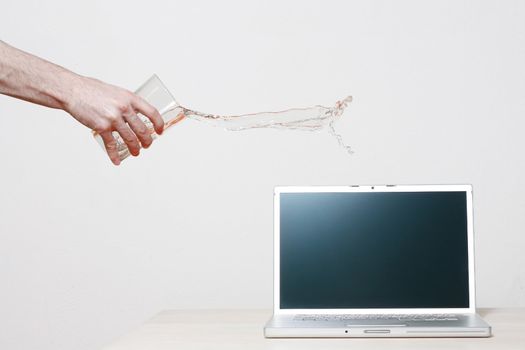 Man accidentally pouring water on laptop