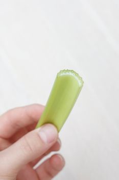 Hand holding a celery stick