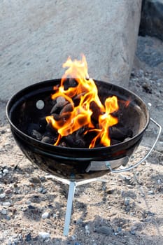 A grill with charcoal and flames