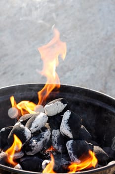 A grill with charcoal and flames