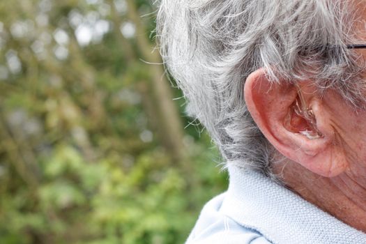 An older man with a hearing device