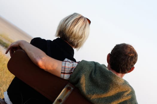 A couple on a bench at sunset