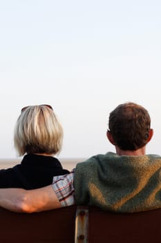 A couple on a bench at sunset