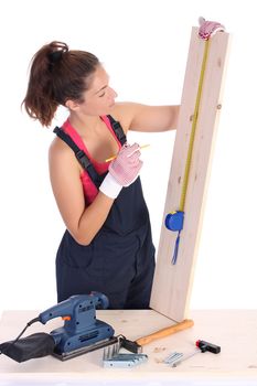 woman carpenter with wooden plank and measuring tape