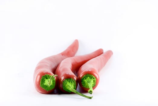 three red chili on white background