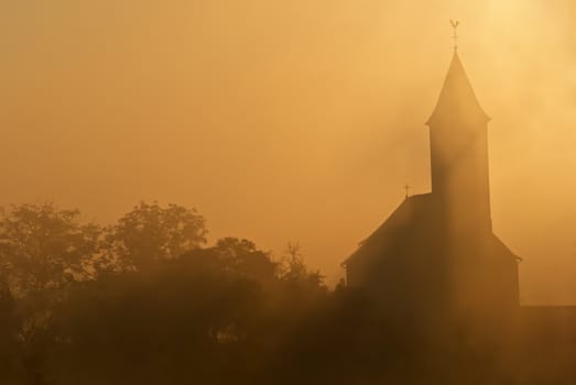 a french church in the morning mist