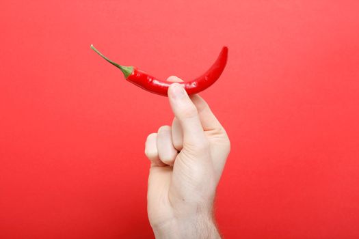 A hand holding chili pepper