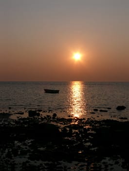 portrait of beautiful sunset beside smal boat