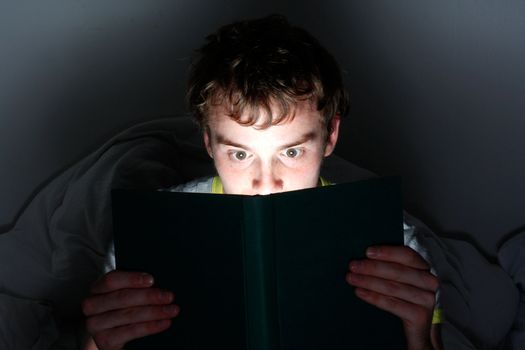 A man reading a book at night