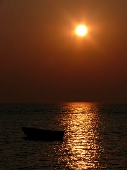 portrait of beautiful sunset beside smal boat