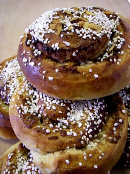 portrait of delicious pile cinnamon buns on wood plate
