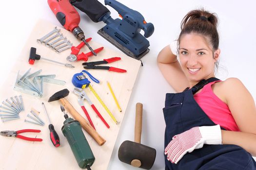 woman carpenter with work tools on wooden plank