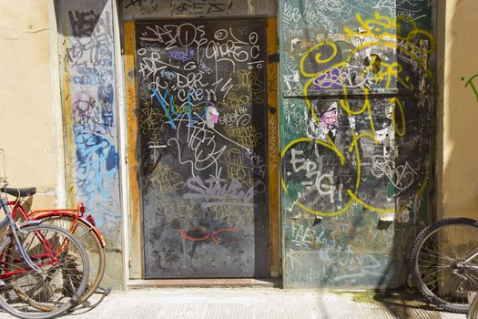 Image of closed iron door covered by graffiti.