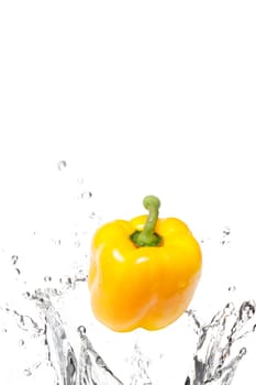 A delicious yellow bell pepper splasing into water