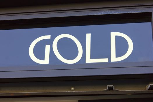 Image of gold sign in front of a golden goods shop.