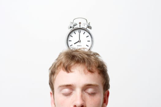 A man with an alarm clock on top of his head