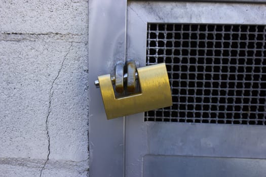 Closeup of a big closed padlock taken outodoors.