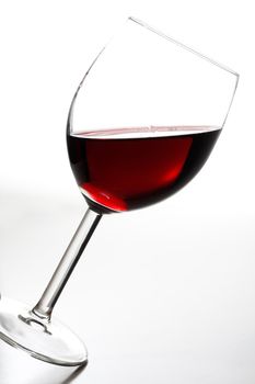 A tilted glass of red wine