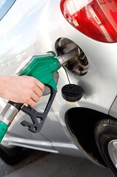 A man pumping gas in to the tank