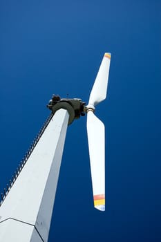 An high mountain wind turbine with blue sky background