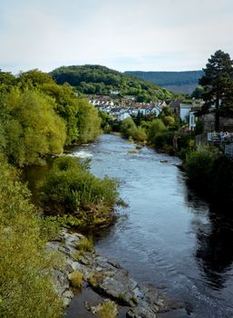 Vertical view of the river in Llangollen in Wales with the town and hills in the background
