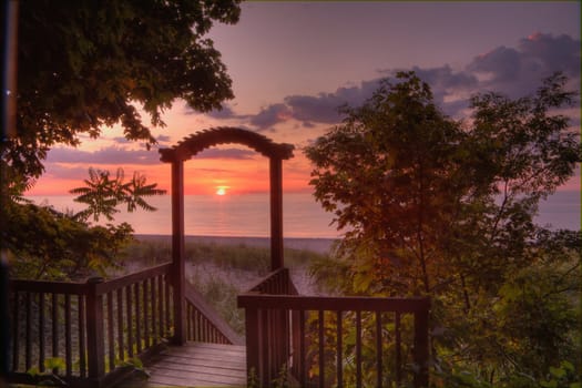 Lake Michigan sunset framed by a wooden arch staircase leading to the beach