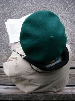 portrait of senior reading a book while sitting on bench