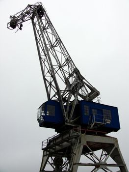 portrait of heavy old industry crane on gray background