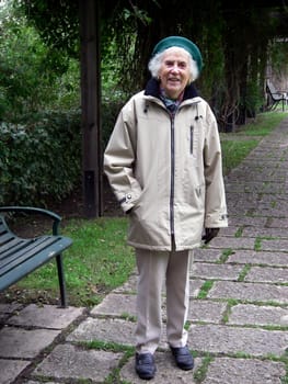 portrait of senior woman standing beside bench in autumn