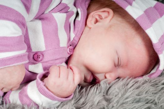 Shot of little cute baby in stripped clothes