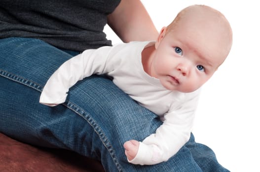 Shot of little cute baby in lying on mother leg