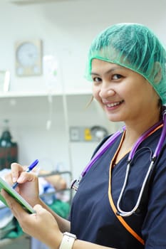 I.C.U. nurse writing in patients' record